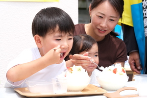 子どもたちが雪くまを食べている写真