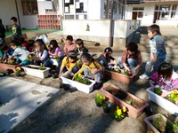 横一列に並んで、花植えの準備をする子ども達