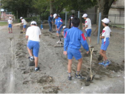 運動委員会で砂場を掘り起こしている写真