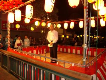 提灯の舞台で挨拶する富岡市長の写真